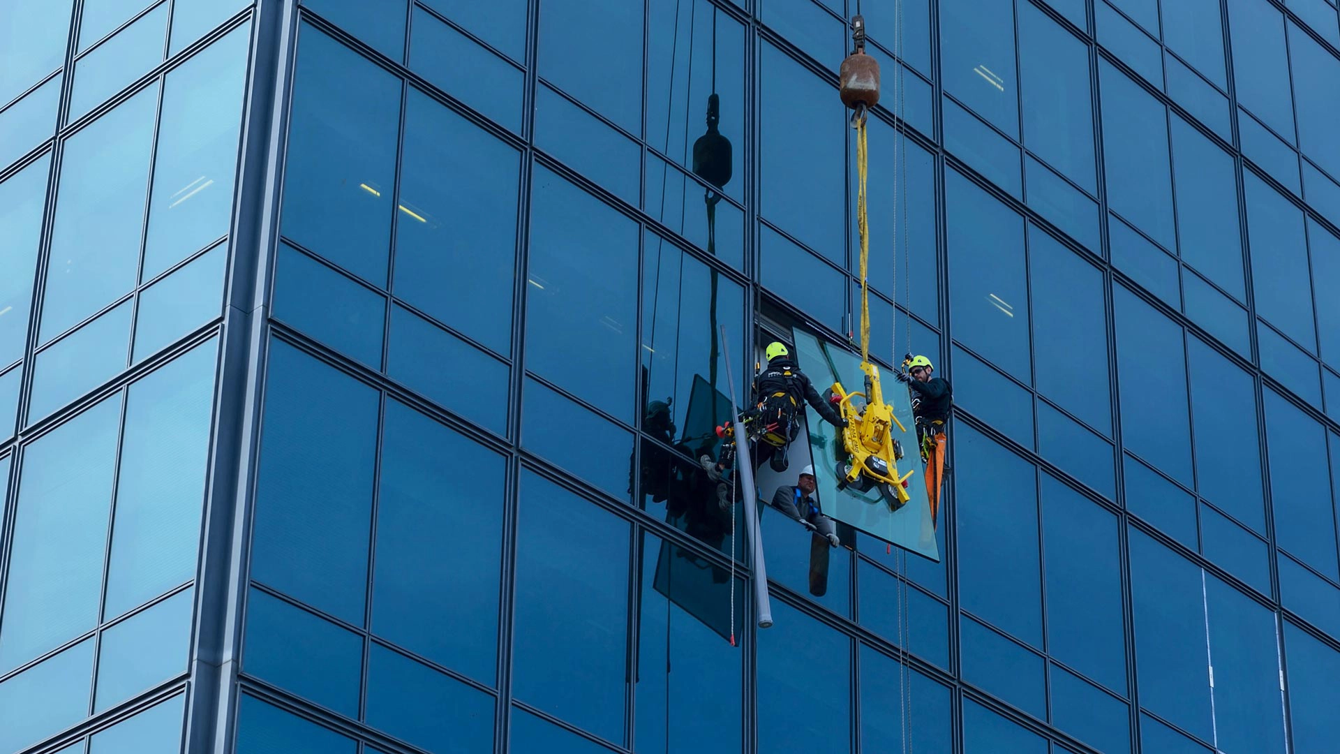 High rise glass building facade reflecting sky
